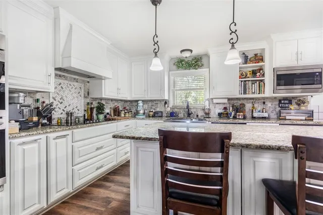 a kitchen with stainless steel appliances granite countertop a sink and cabinets