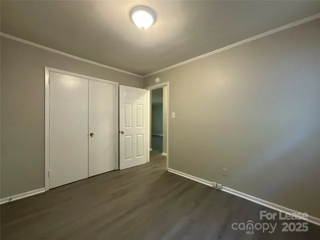 an empty room with wooden floor and closet