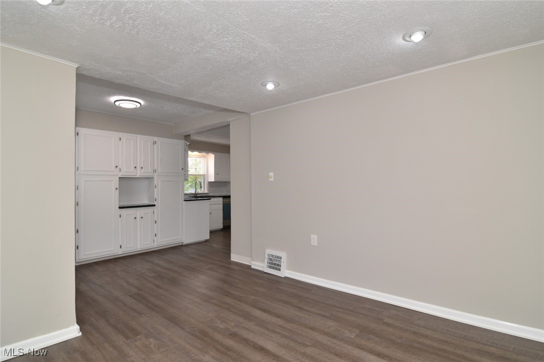 1443 Churchill Road Lyndhurst, OH 44124 - Photo 12 of 39 Unfurnished living room with dark wood-style floors and a textured ceiling