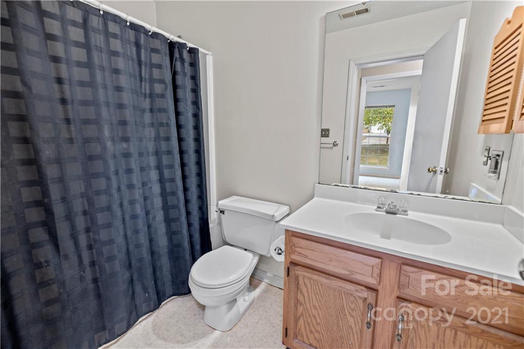 11232 Clayford Ridge Charlotte, NC 28215 - Photo 16 of 22 a bathroom with a sink a toilet and shower curtain
