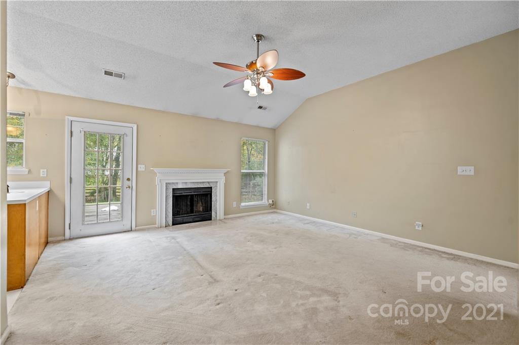 11232 Clayford Ridge Charlotte, NC 28215 - Photo 4 of 22 a view of an empty room with a fireplace and a window
