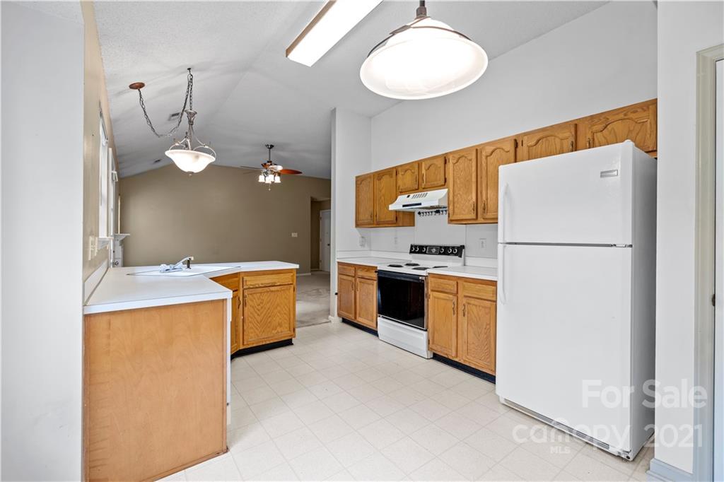 11232 Clayford Ridge Charlotte, NC 28215 - Photo 6 of 22 a kitchen with a refrigerator a stove top oven and a sink