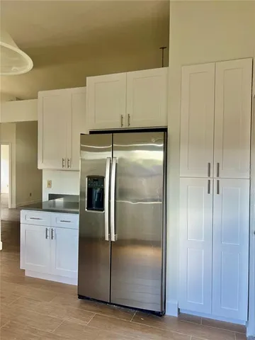 a kitchen with granite countertop a refrigerator and a sink