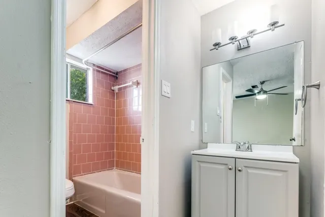 a bathroom with a granite countertop sink a mirror and a bathtub