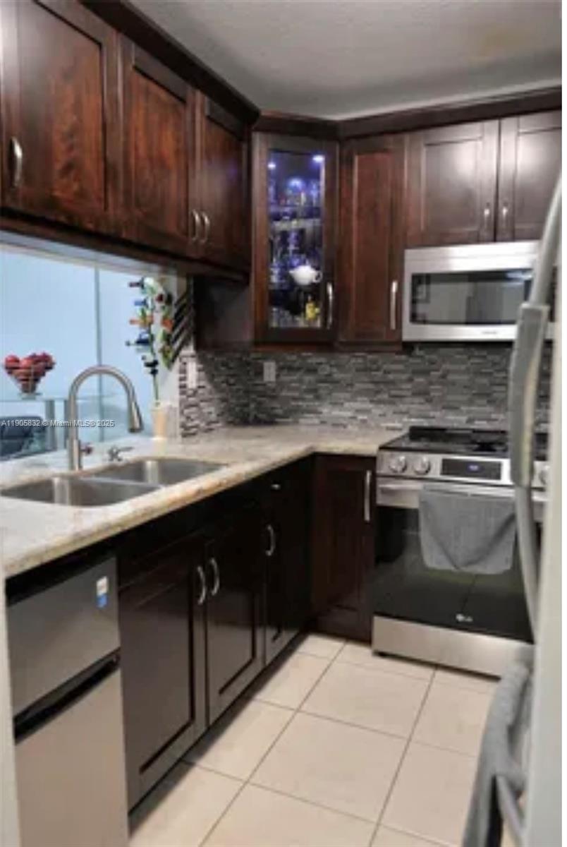 a kitchen with stainless steel appliances a sink stove and cabinets
