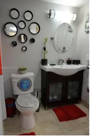 a bathroom with a toilet sink and mirror