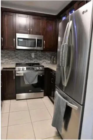 a kitchen with granite countertop a refrigerator and a stove