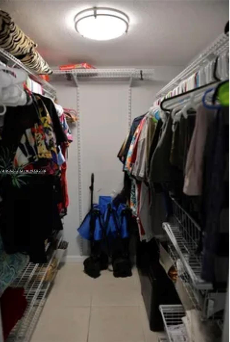 10900 Southwest 104th Street, Unit 314 Miami, FL 33176 - Photo 9 of 13 a view of walk in closet with clothes and shoes