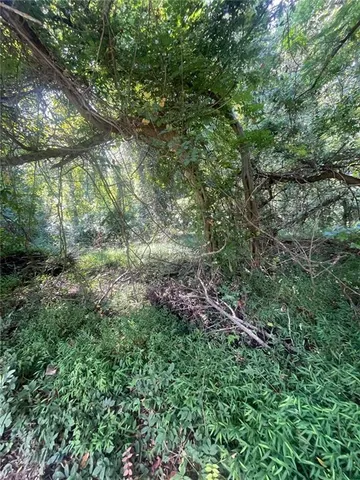 a sign that is sitting in front of a tree