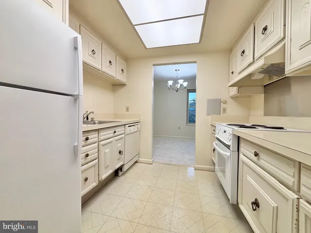 a kitchen with granite countertop cabinets and white appliances