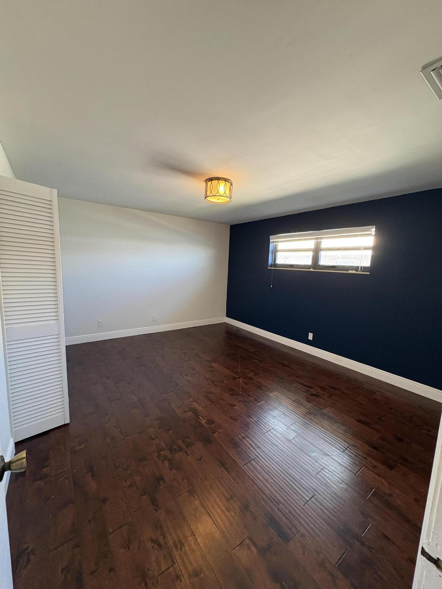 360 Wilma Circle, Unit 5 Riviera Beach, FL 33404 - Photo 13 of 16 an empty room with wooden floor and windows