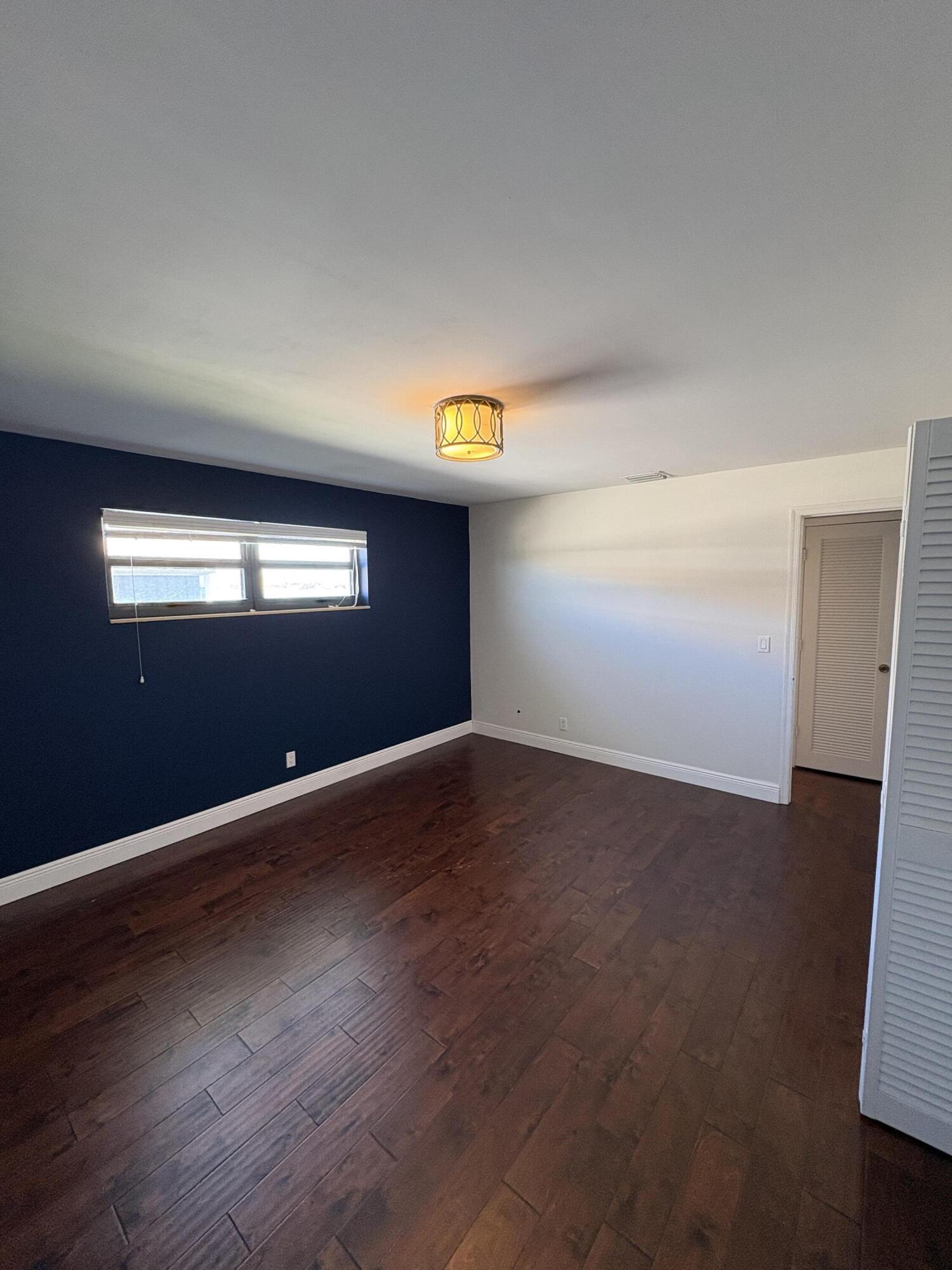360 Wilma Circle, Unit 5 Riviera Beach, FL 33404 - Photo 14 of 16 a view of empty room with window and wooden floor