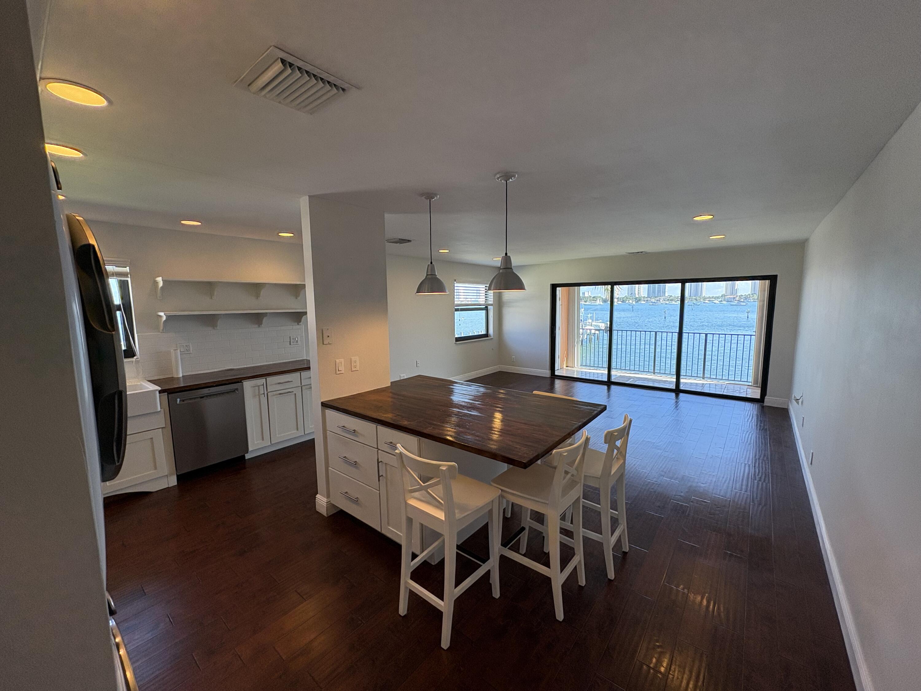 360 Wilma Circle, Unit 5 Riviera Beach, FL 33404 - Photo 5 of 16 a kitchen with a table chairs refrigerator and cabinets