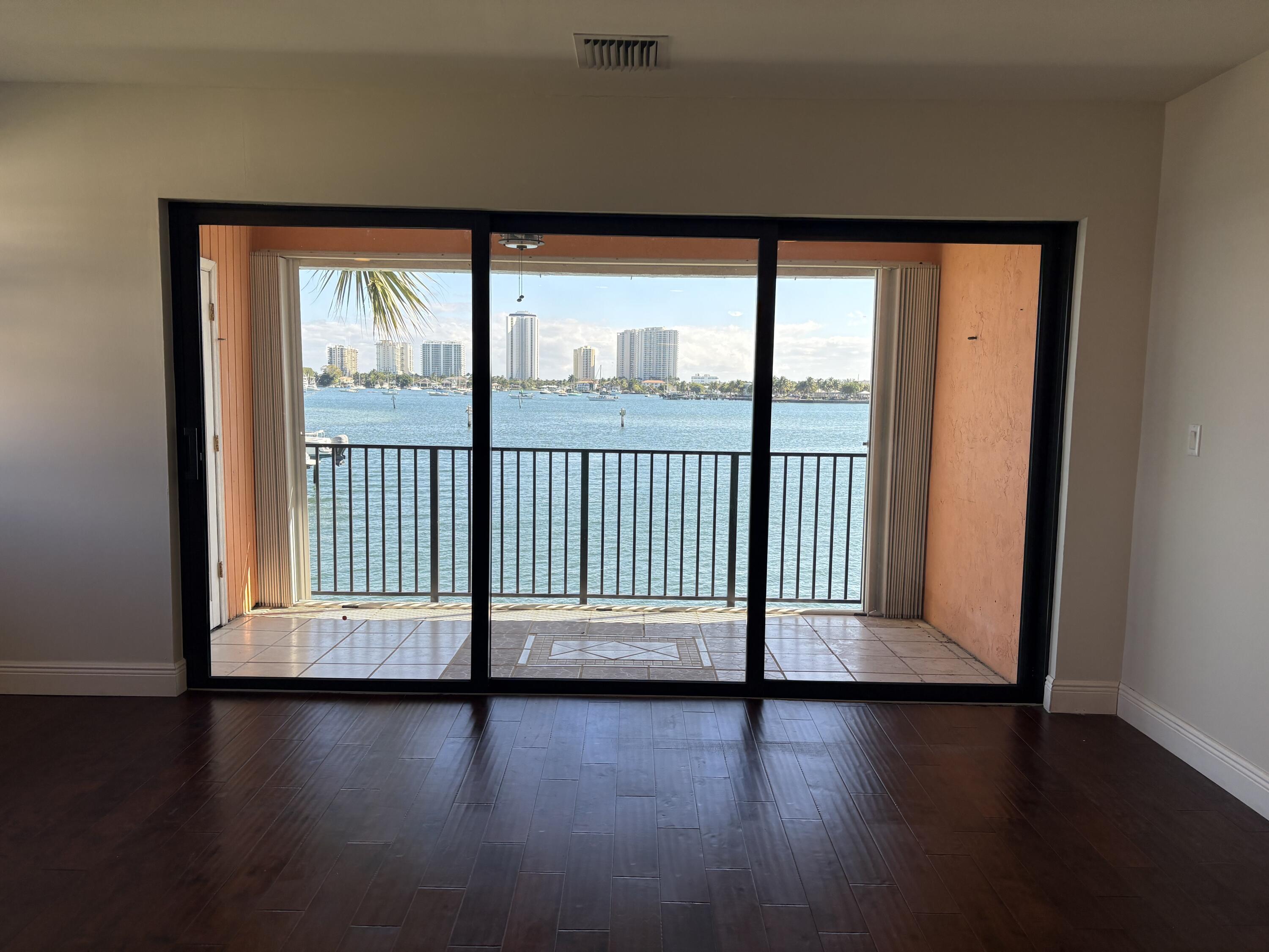 360 Wilma Circle, Unit 5 Riviera Beach, FL 33404 - Photo 9 of 16 a view of empty room with wooden floor and fan