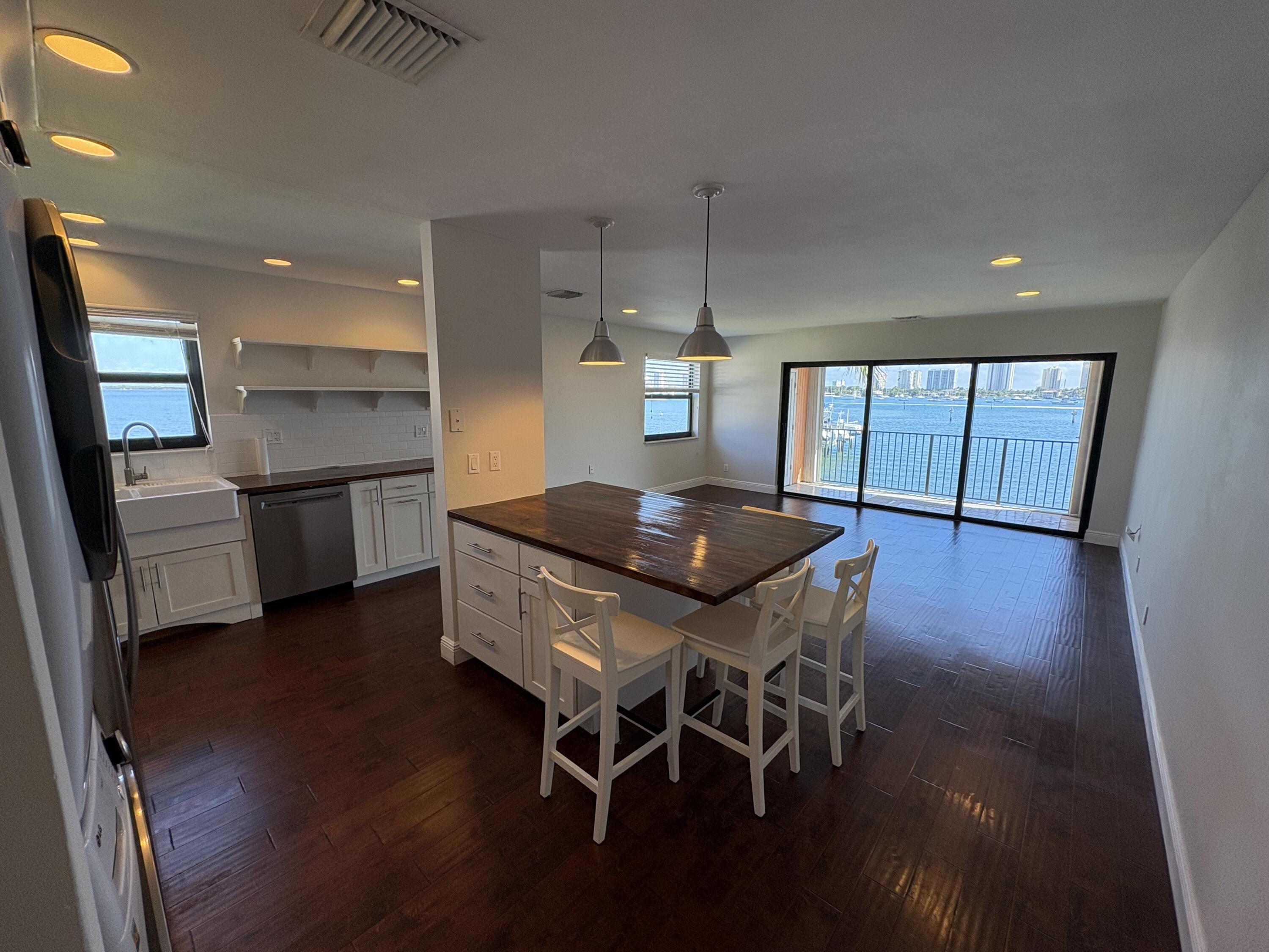 360 Wilma Circle, Unit 5 Riviera Beach, FL 33404 - Photo 10 of 16 a kitchen with stainless steel appliances a dining table chairs and wooden floor