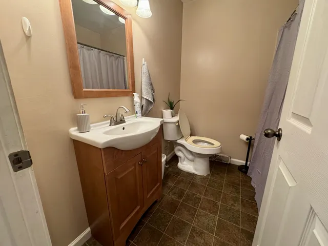 a bathroom with a sink a toilet and a mirror