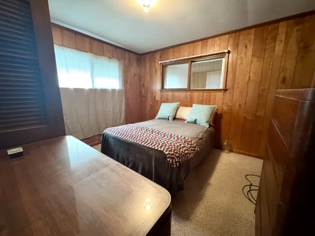 a bedroom with a bed and a mirror