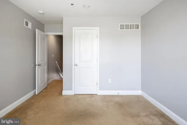 an empty room with windows and closet