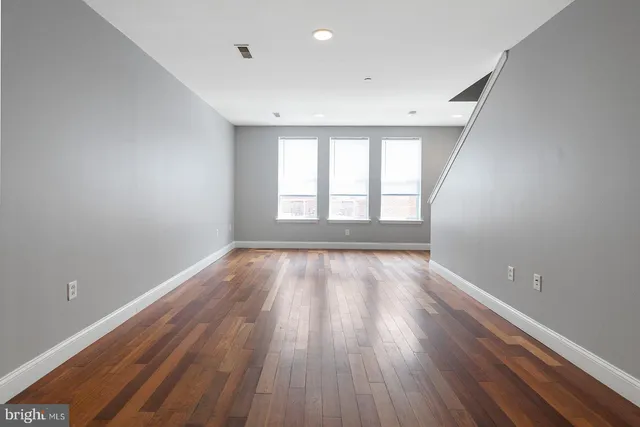 a kitchen with stainless steel appliances white cabinets a sink a stove a microwave and wooden floors
