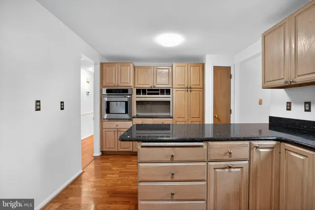 a kitchen with granite countertop white cabinets and stainless steel appliances