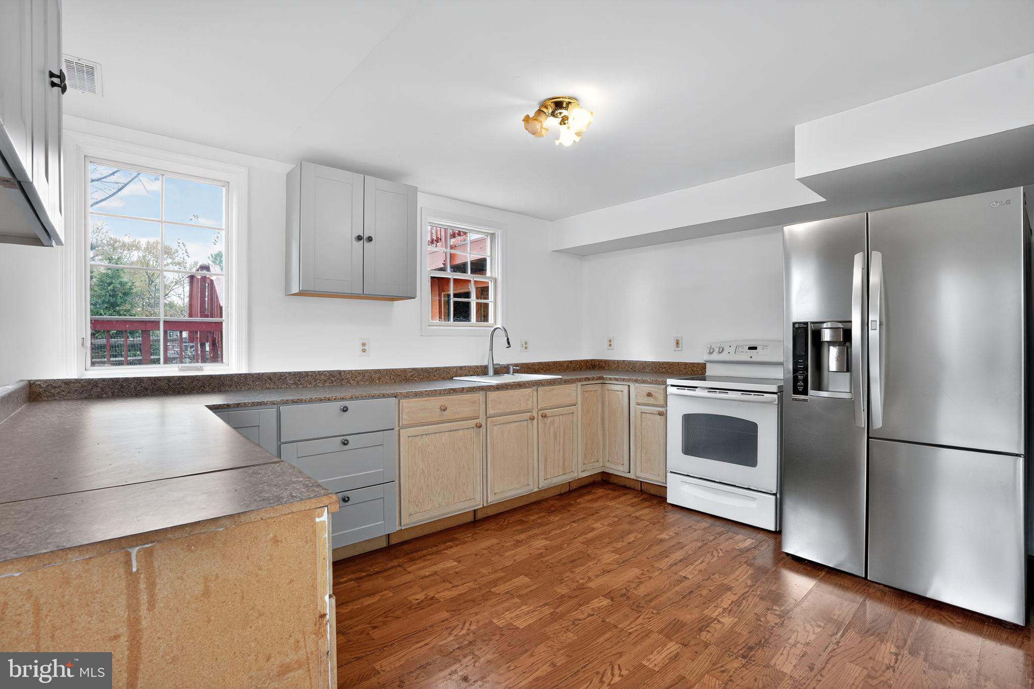 1513 Rainbow Drive Silver Spring, MD 20905 - Photo 15 of 58 a kitchen with a refrigerator and white cabinets