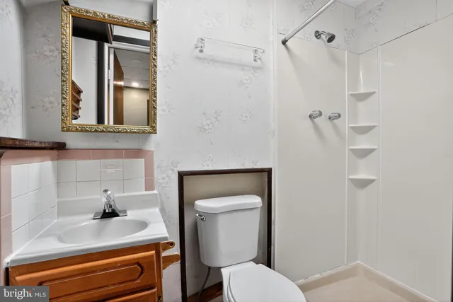 a bathroom with a sink a toilet and shower