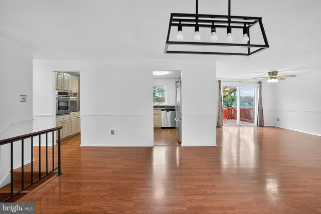 a view of a hallway with wooden floor and windows