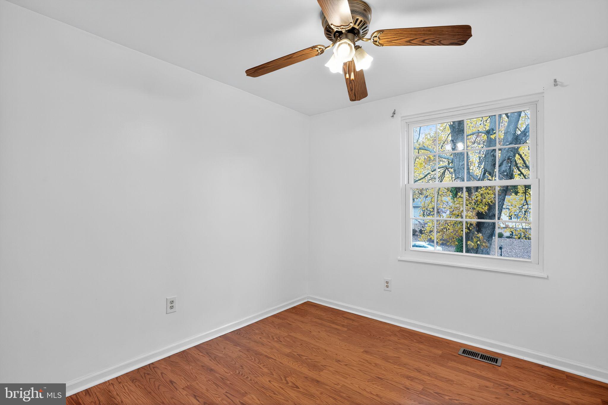 1513 Rainbow Drive Silver Spring, MD 20905 - Photo 31 of 58 an empty room with wooden floor fan and windows