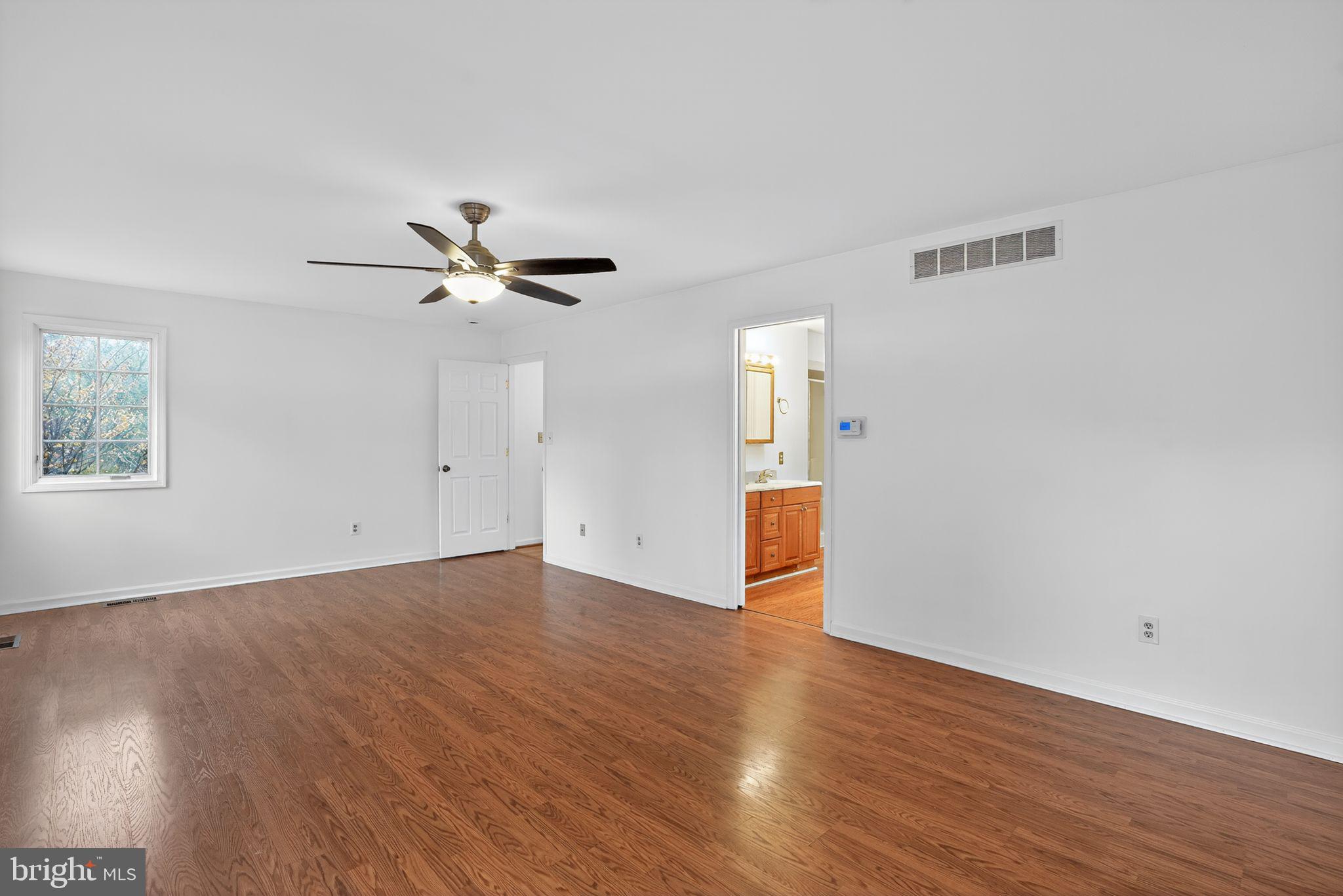 1513 Rainbow Drive Silver Spring, MD 20905 - Photo 32 of 58 an empty room with wooden floor and windows