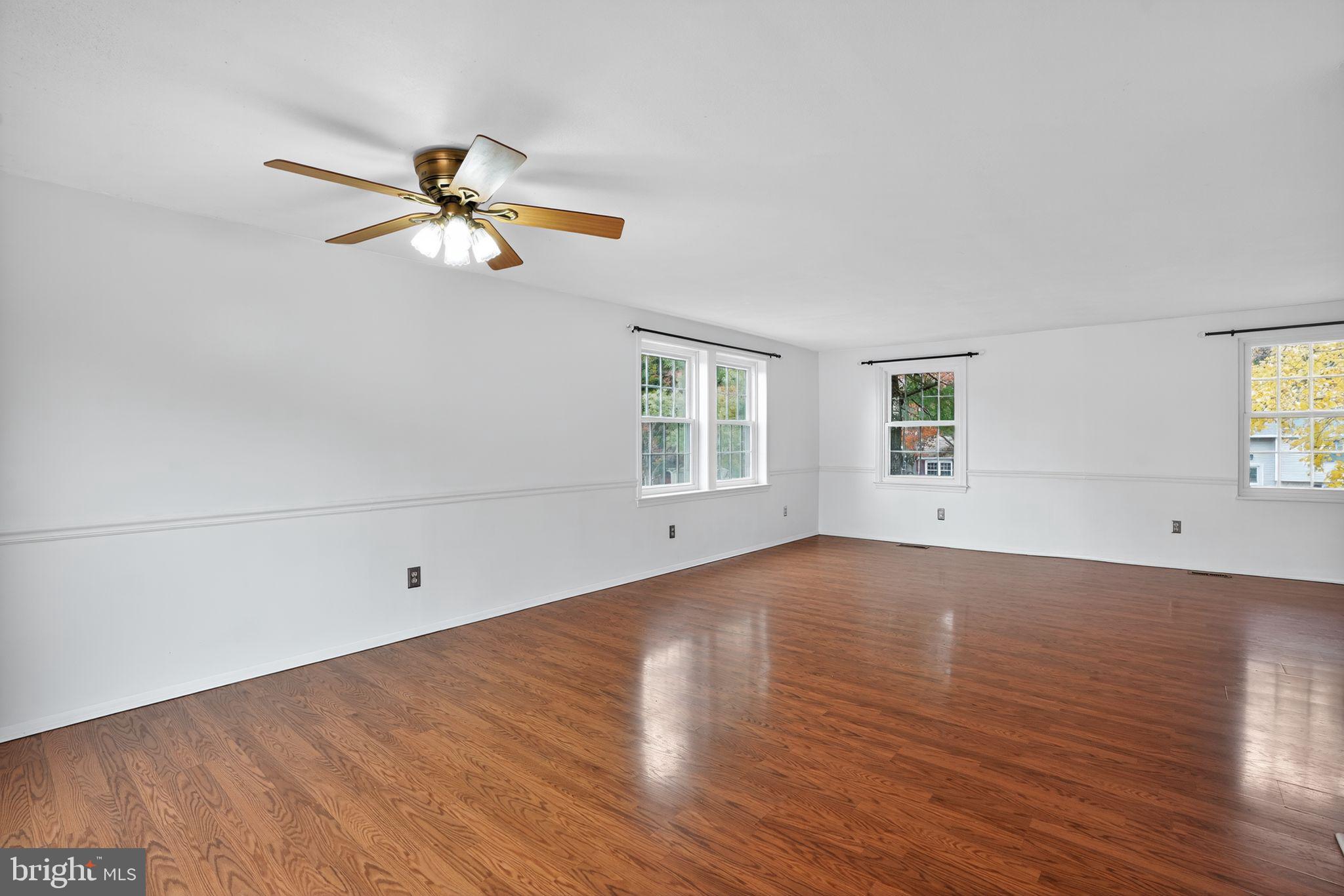 1513 Rainbow Drive Silver Spring, MD 20905 - Photo 35 of 58 an empty room with wooden floor fan and windows