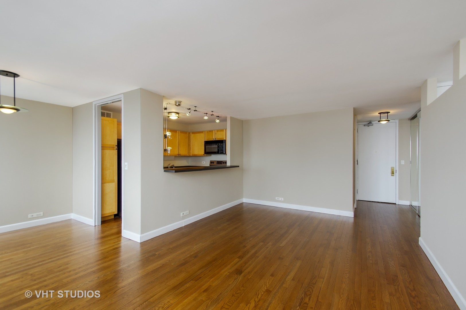 655 West Irving Park Road, Unit 2713 Chicago, IL 60613 - Photo 11 of 26 a view of an empty room with wooden floor and a window
