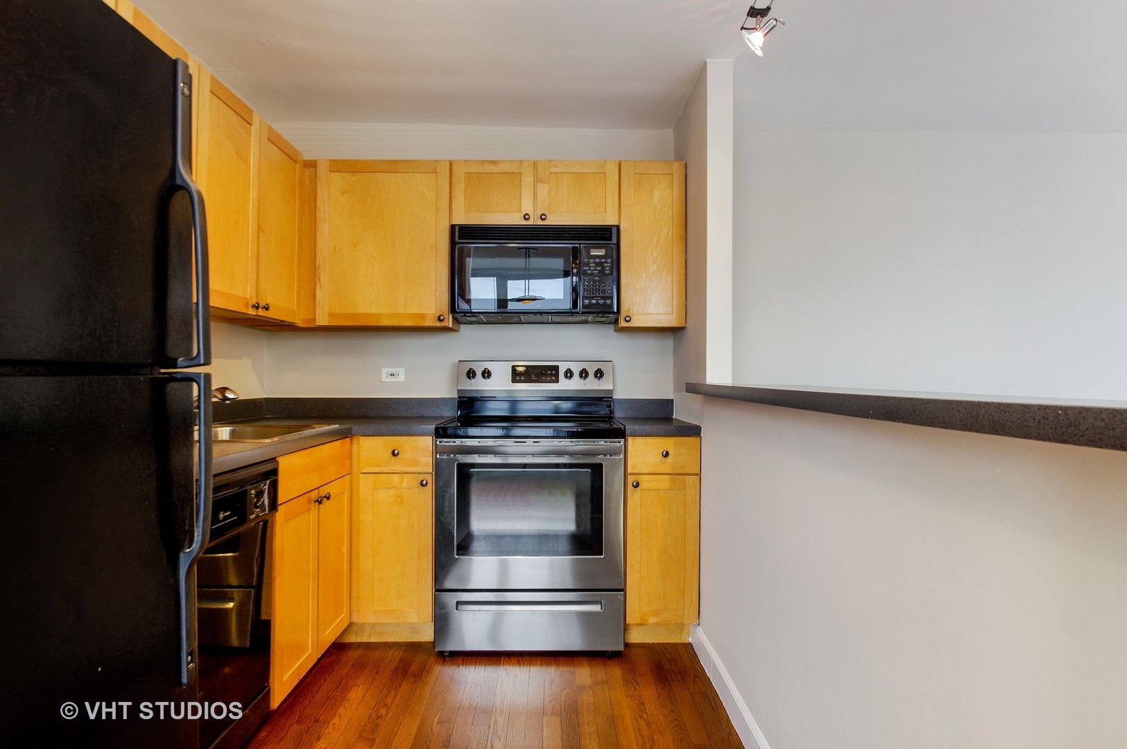 655 West Irving Park Road, Unit 2713 Chicago, IL 60613 - Photo 14 of 26 a kitchen with stainless steel appliances granite countertop a stove a sink and a microwave