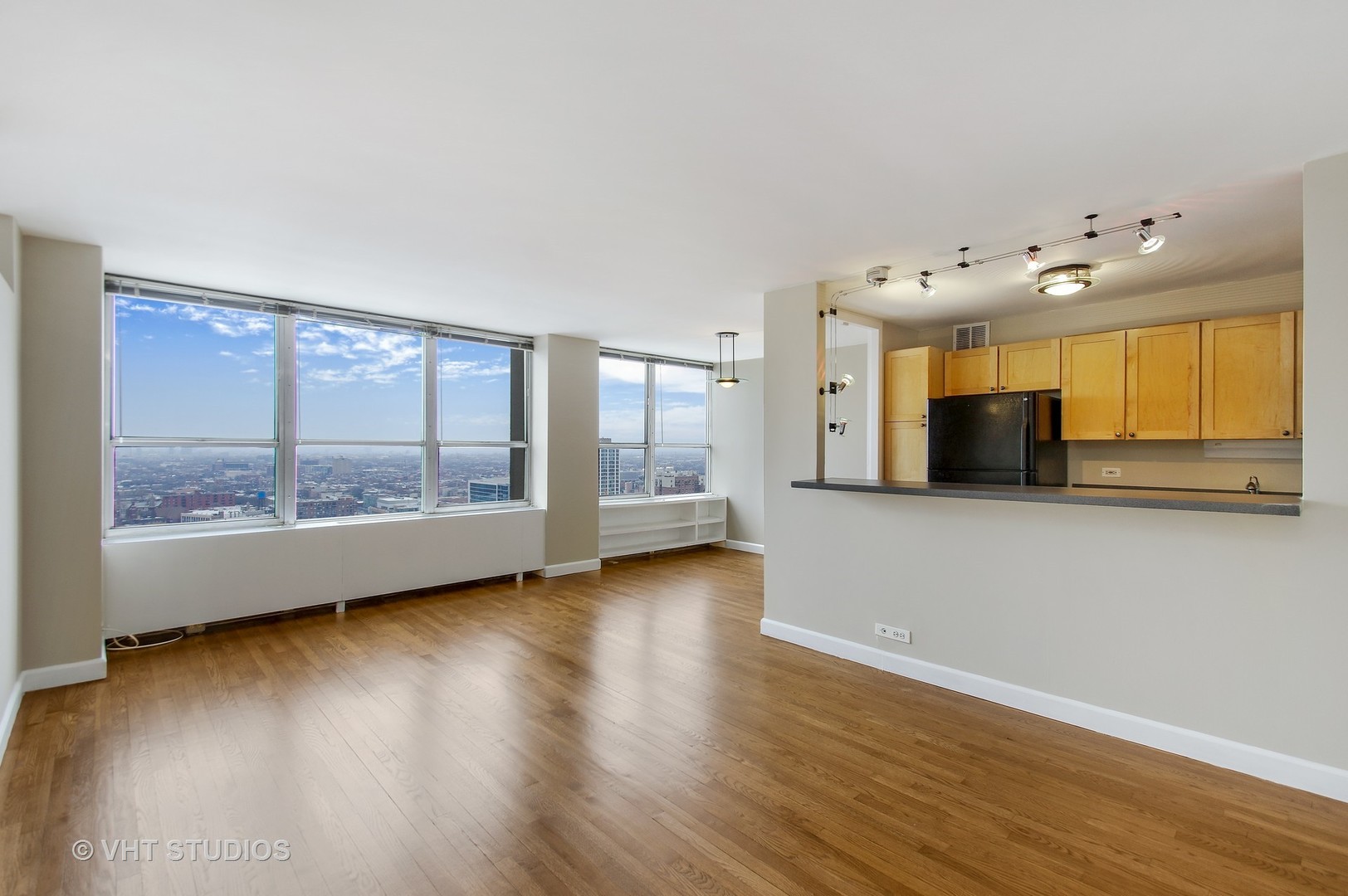655 West Irving Park Road, Unit 2713 Chicago, IL 60613 - Photo 9 of 26 a view of an empty room with a window and wooden floor