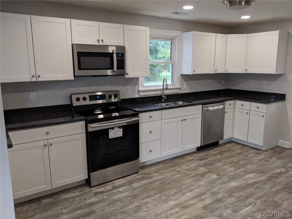 8523 Peaks Road Hanover, VA 23069 - Photo 11 of 35 a kitchen with granite countertop white cabinets a sink and white appliances