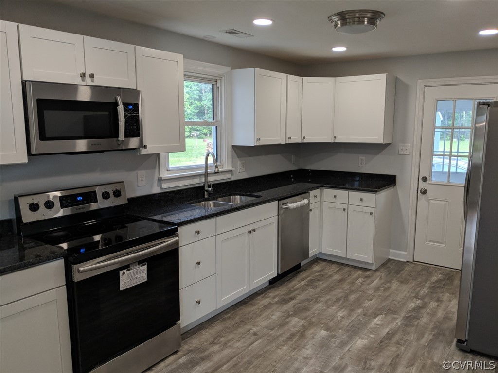 8523 Peaks Road Hanover, VA 23069 - Photo 13 of 35 a kitchen with granite countertop white cabinets and black appliances