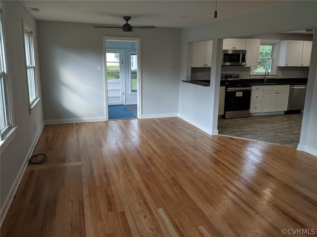 8523 Peaks Road Hanover, VA 23069 - Photo 8 of 35 an empty room with wooden floor kitchen view and a window