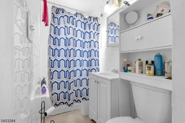 a bathroom with a sink toilet and shower curtain