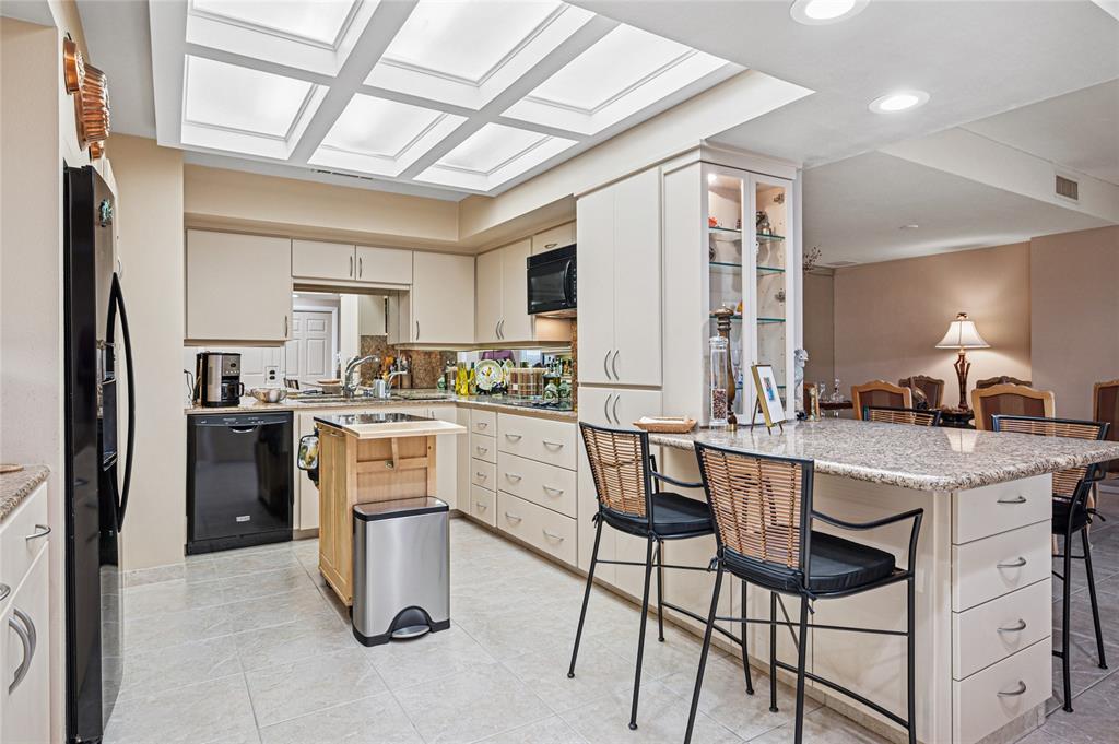 5200 Keller Springs Road, Unit 632 Dallas, TX 75248 - Photo 14 of 36 a kitchen with white cabinets and stainless steel appliances