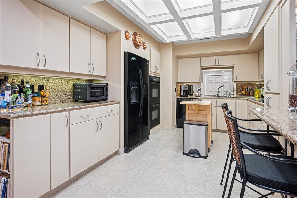 5200 Keller Springs Road, Unit 632 Dallas, TX 75248 - Photo 15 of 36 a kitchen with stainless steel appliances kitchen island granite countertop a refrigerator and microwave