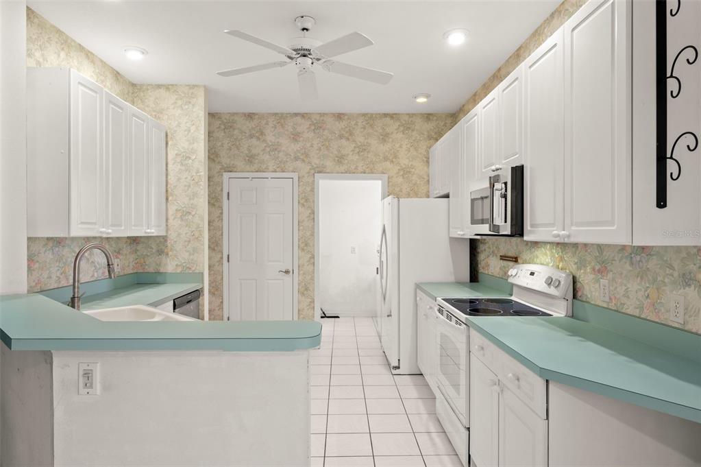4333 Spicetree Street Venice, FL 34293 - Photo 14 of 29 a kitchen with a sink a counter top space cabinets and stainless steel appliances