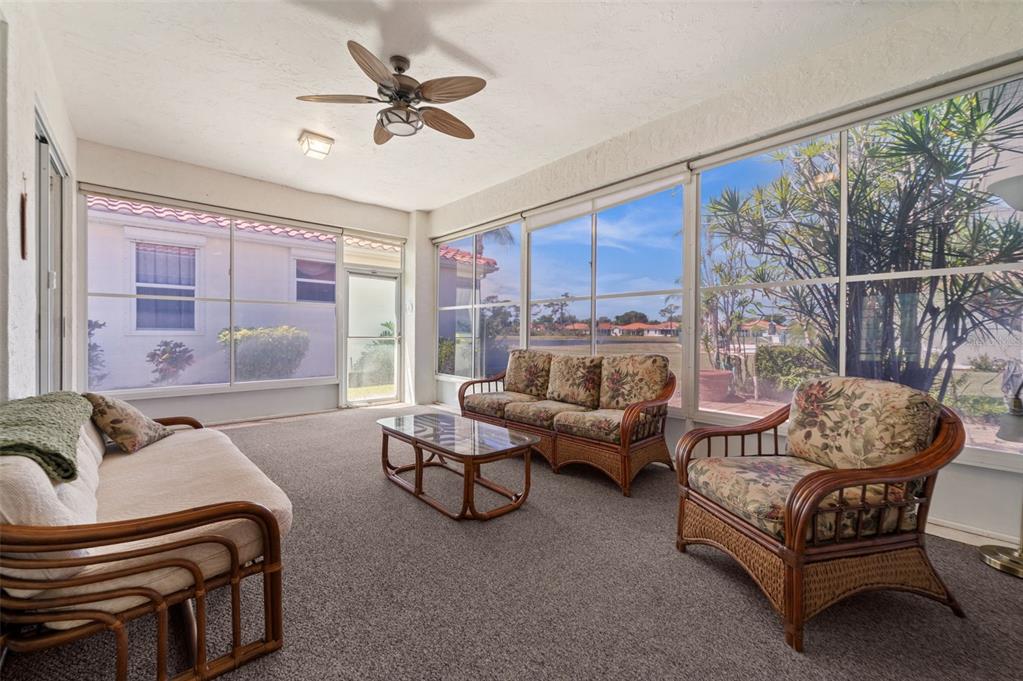 4333 Spicetree Street Venice, FL 34293 - Photo 16 of 29 a living room with furniture and a floor to ceiling window