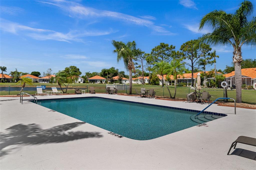 4333 Spicetree Street Venice, FL 34293 - Photo 29 of 29 a view of a swimming pool with a lawn chairs under an umbrella