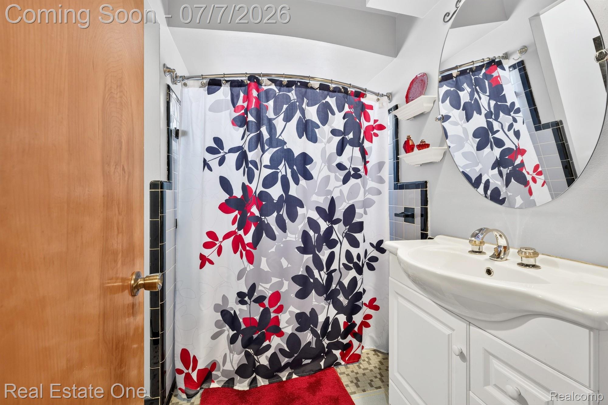 24749 Munson Street Taylor, MI 48180 - Photo 10 of 28 Bathroom featuring a white vanity with integrated sink, chrome faucet, and a round wall mirror