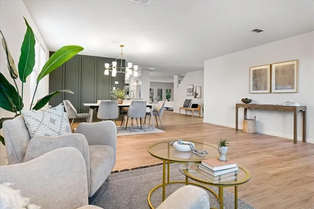 a spacious bedroom with a bed a couch and chandelier