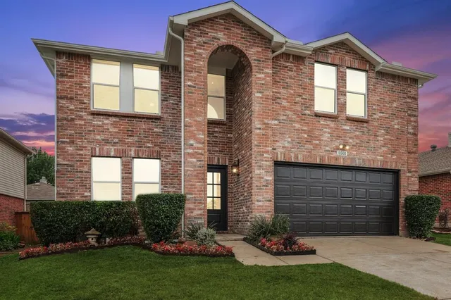 a front view of a house with a garden and plants