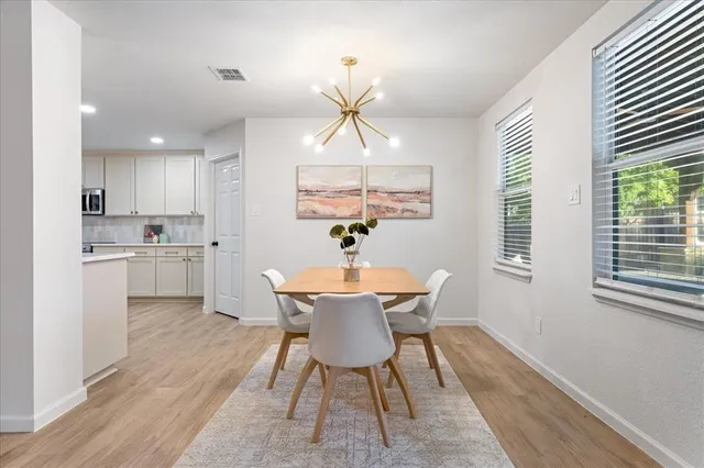 a kitchen with stainless steel appliances a dining table chairs and a chandelier