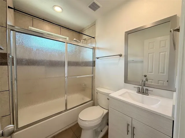 a bathroom with a shower sink vanity mirror and toilet