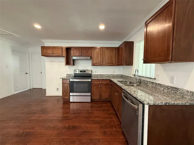 a kitchen with stainless steel appliances granite countertop a stove a sink and a refrigerator