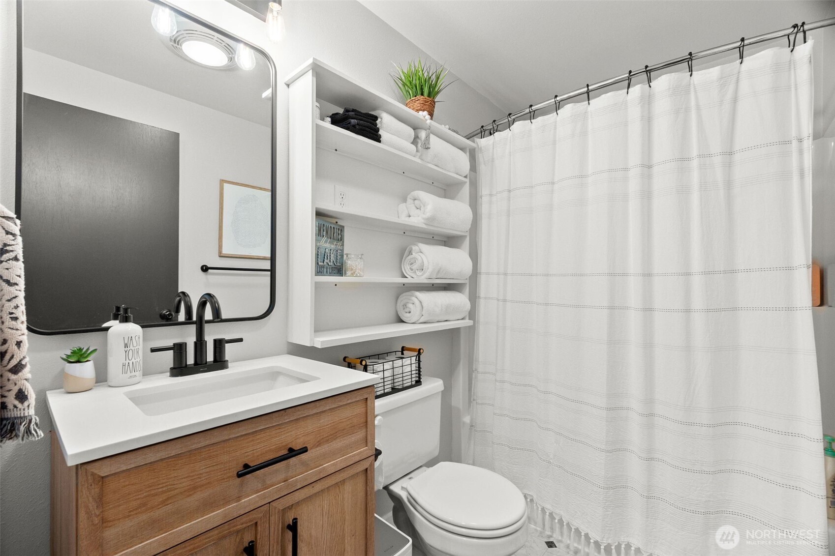 1521 Summit Lake Shore Road Northwest Olympia, WA 98502 - Photo 30 of 40 a bathroom with a sink a toilet a mirror and shower curtain
