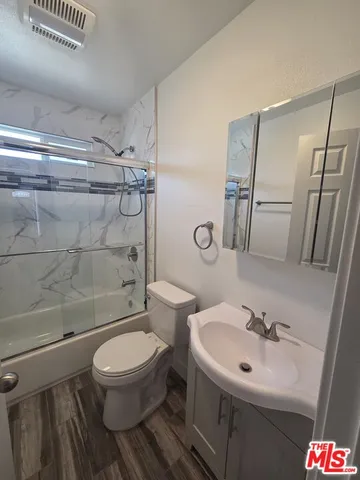 a bathroom with a toilet sink shower and mirror